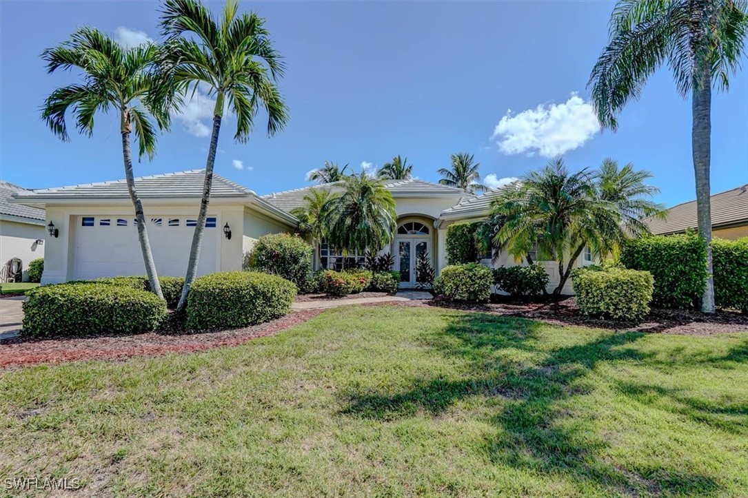 a view of a house with a yard and potted plants