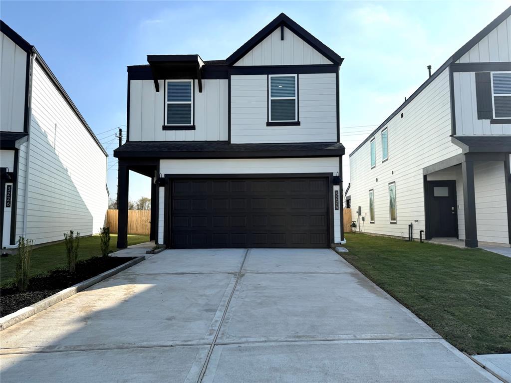 Modern two-story home with a sleek black and white exterior, featuring a spacious driveway and attached garage. The property includes minimal landscaping and a fenced backyard. Perfect for buyers seeking contemporary design and low maintenance.