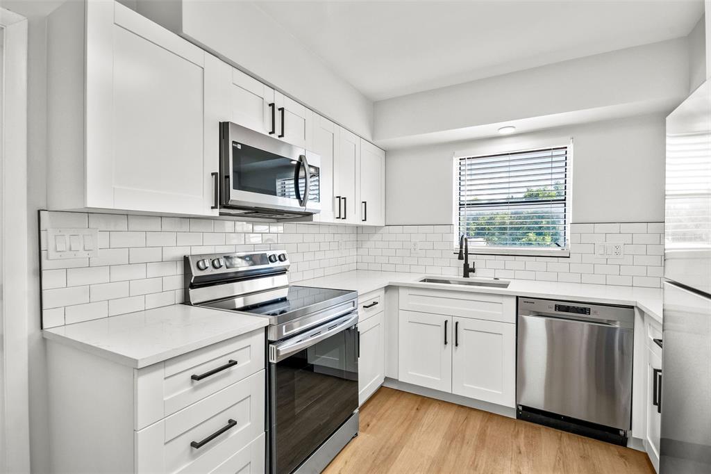 a kitchen with a sink stove and microwave