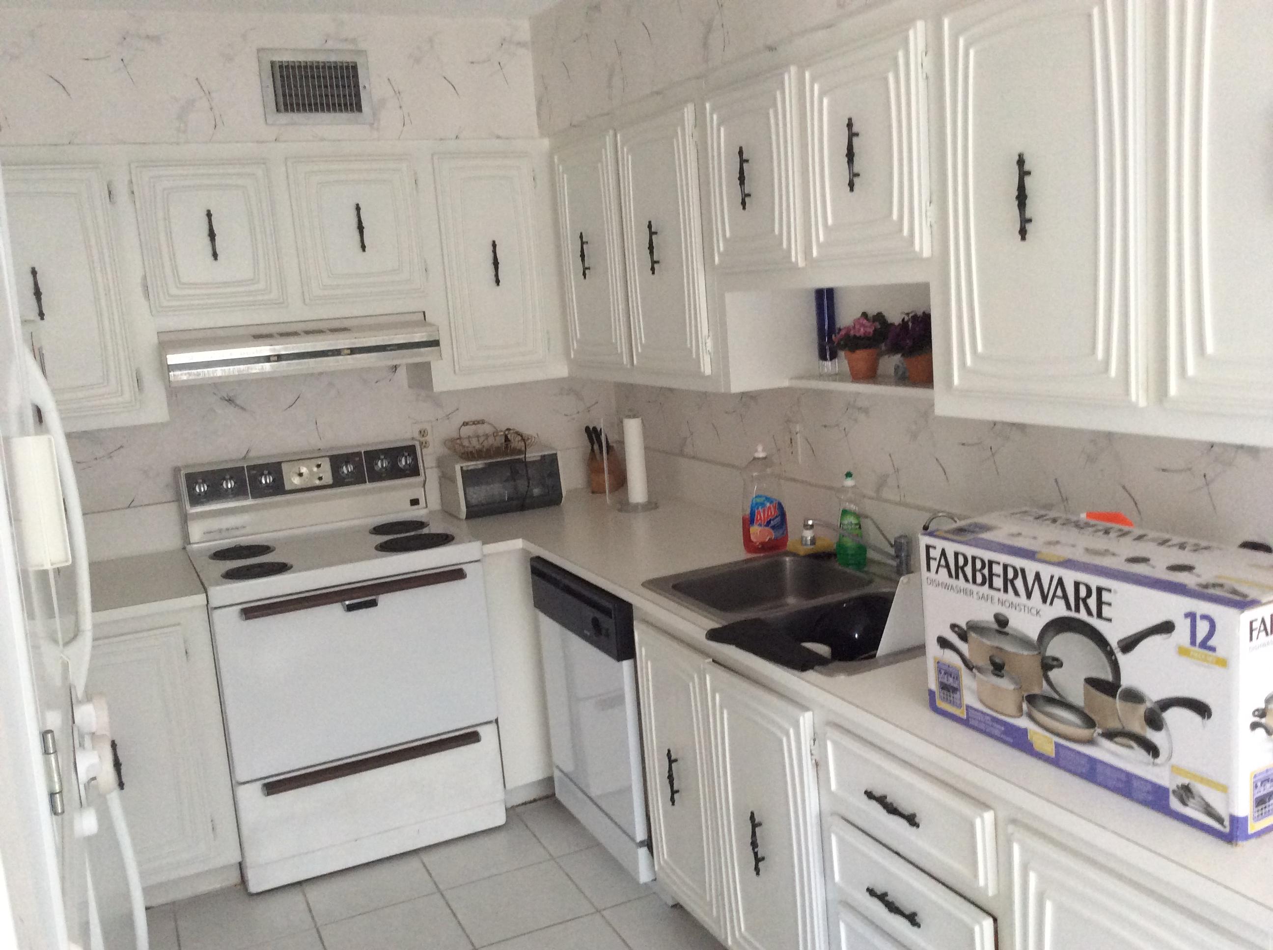 a kitchen with white cabinets and white appliances