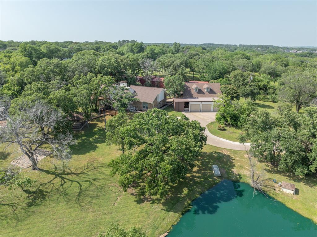 an aerial view of residential house with outdoor space and trees all around