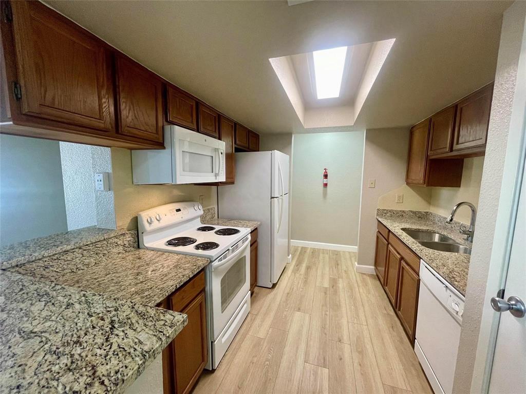 The updated kitchen features stunning granite countertops that add a touch of elegance, complemented by new appliances that enhance functionality. A sleek refrigerator is included, seamlessly blending with the contemporary design.