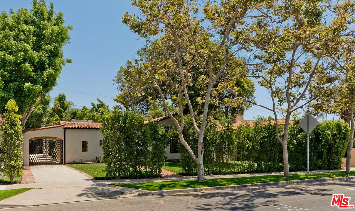 a front view of a house with a yard and trees