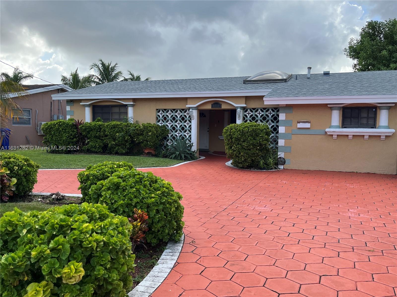 a front view of a house with a yard and potted plants