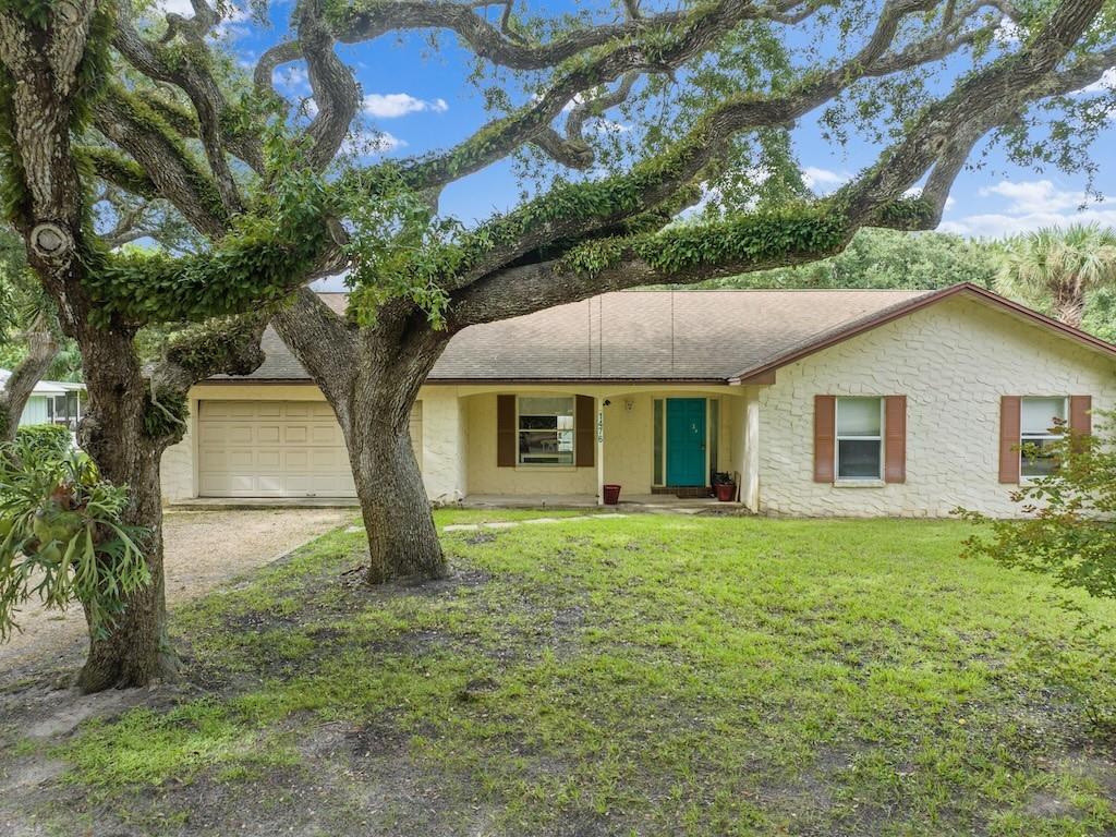 a view of a yard in front of a house with large trees