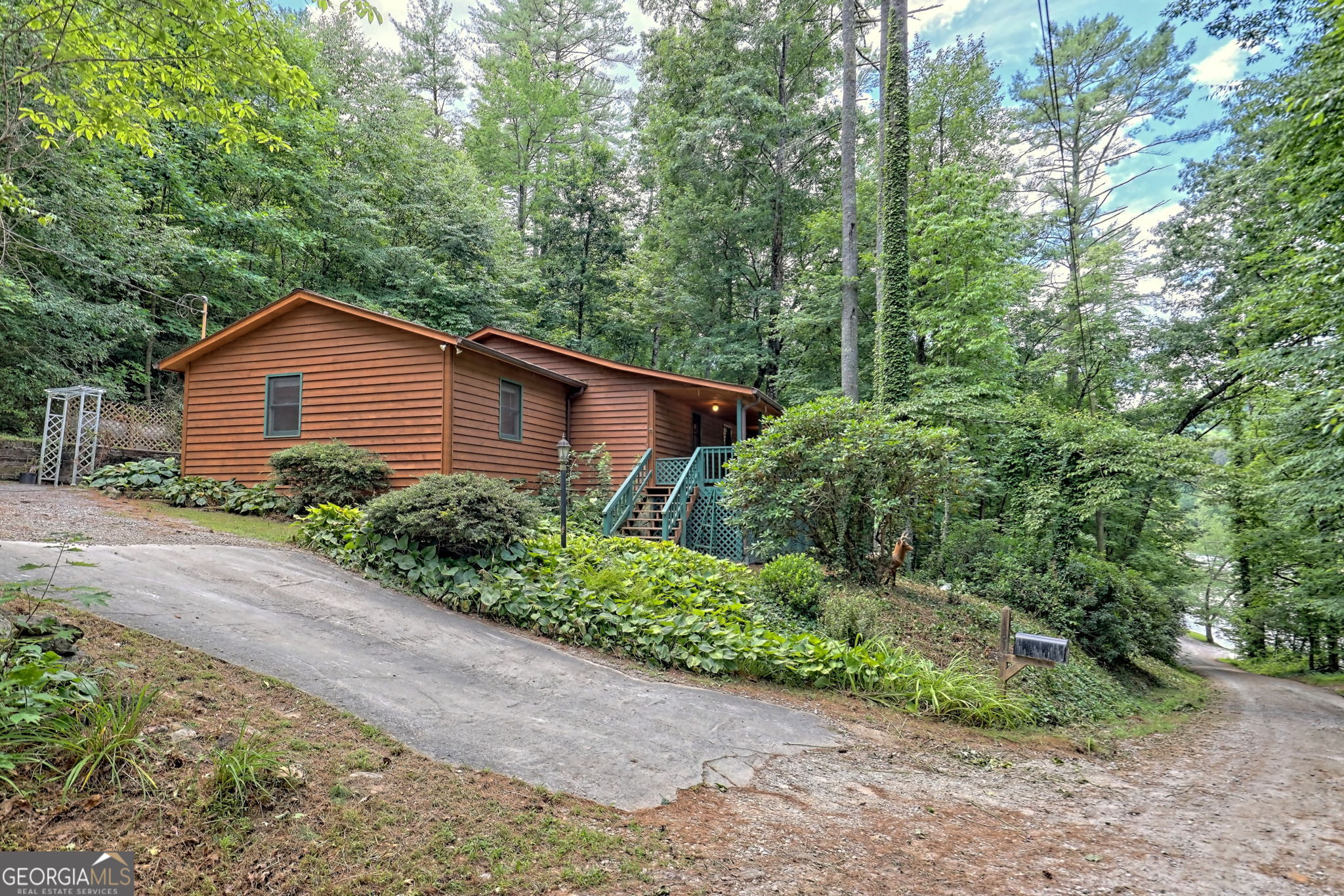 a view of a house with a yard and large trees