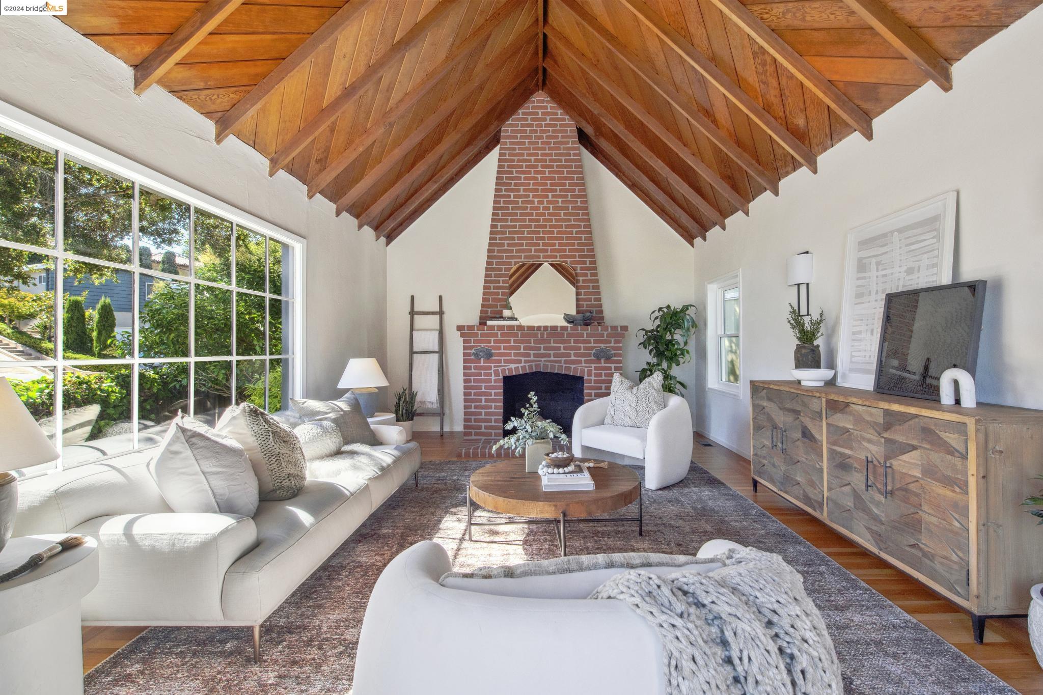 a living room with furniture a fireplace a large window and a flat screen tv