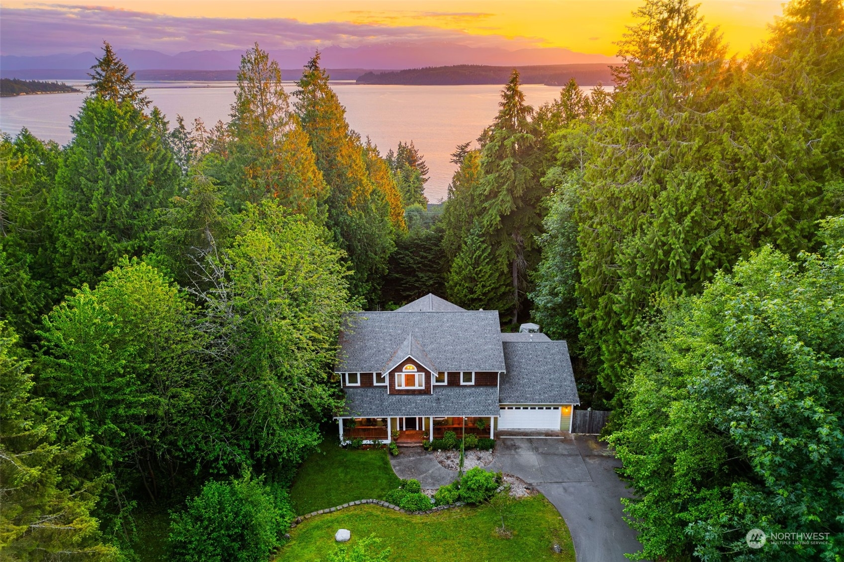 a view of a big house with a big yard and large trees