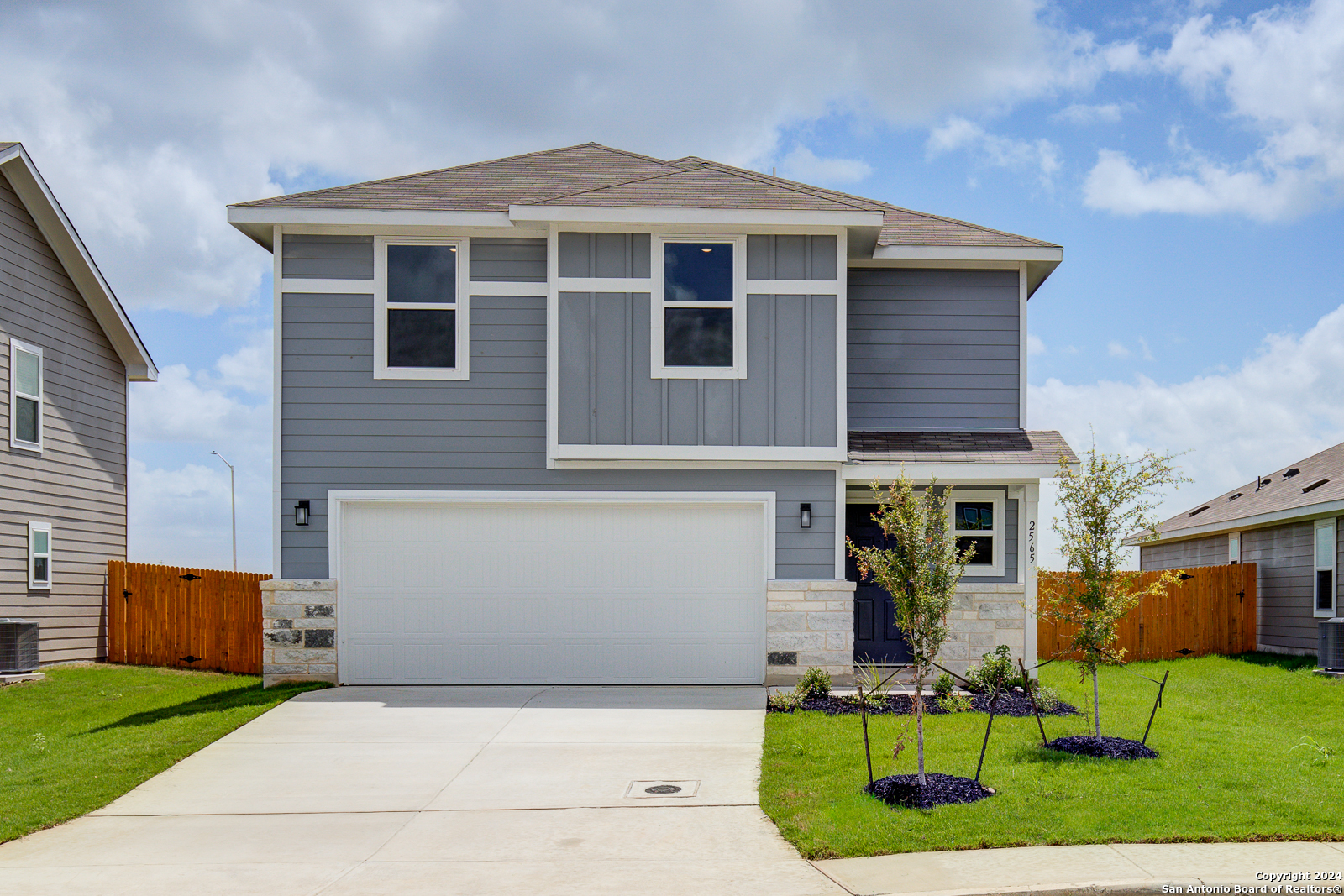 a front view of a house with a yard and chairs