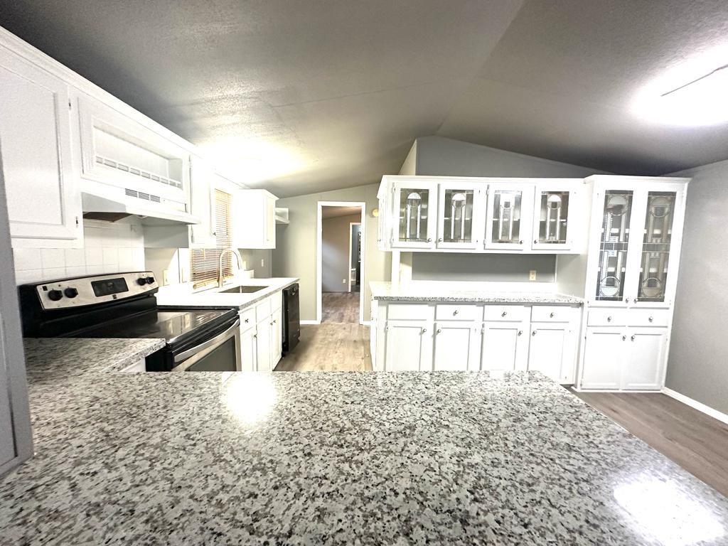 a kitchen with stainless steel appliances granite countertop a stove a sink and a refrigerator