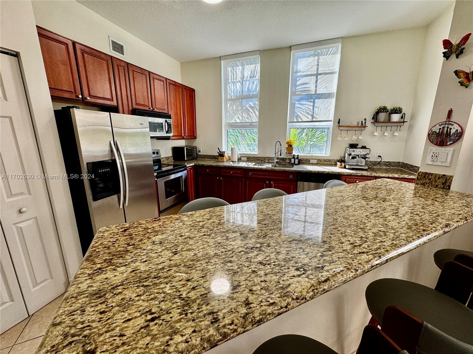 a kitchen with kitchen island granite countertop a sink stove and refrigerator