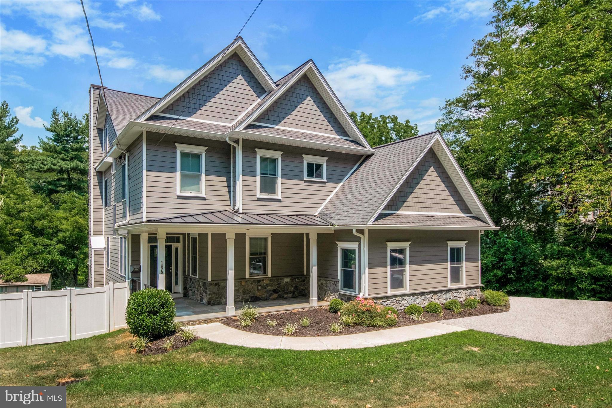 a front view of a house with a yard and green space