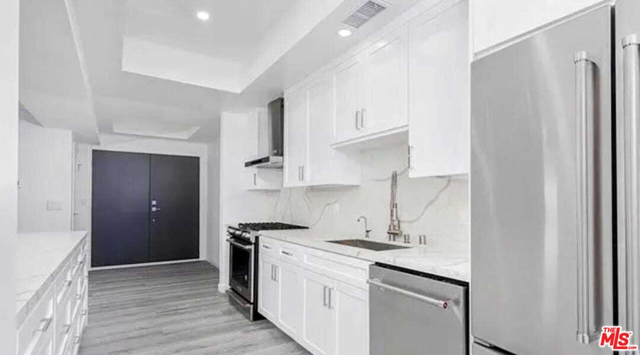 a kitchen with stainless steel appliances granite countertop a sink stove and refrigerator