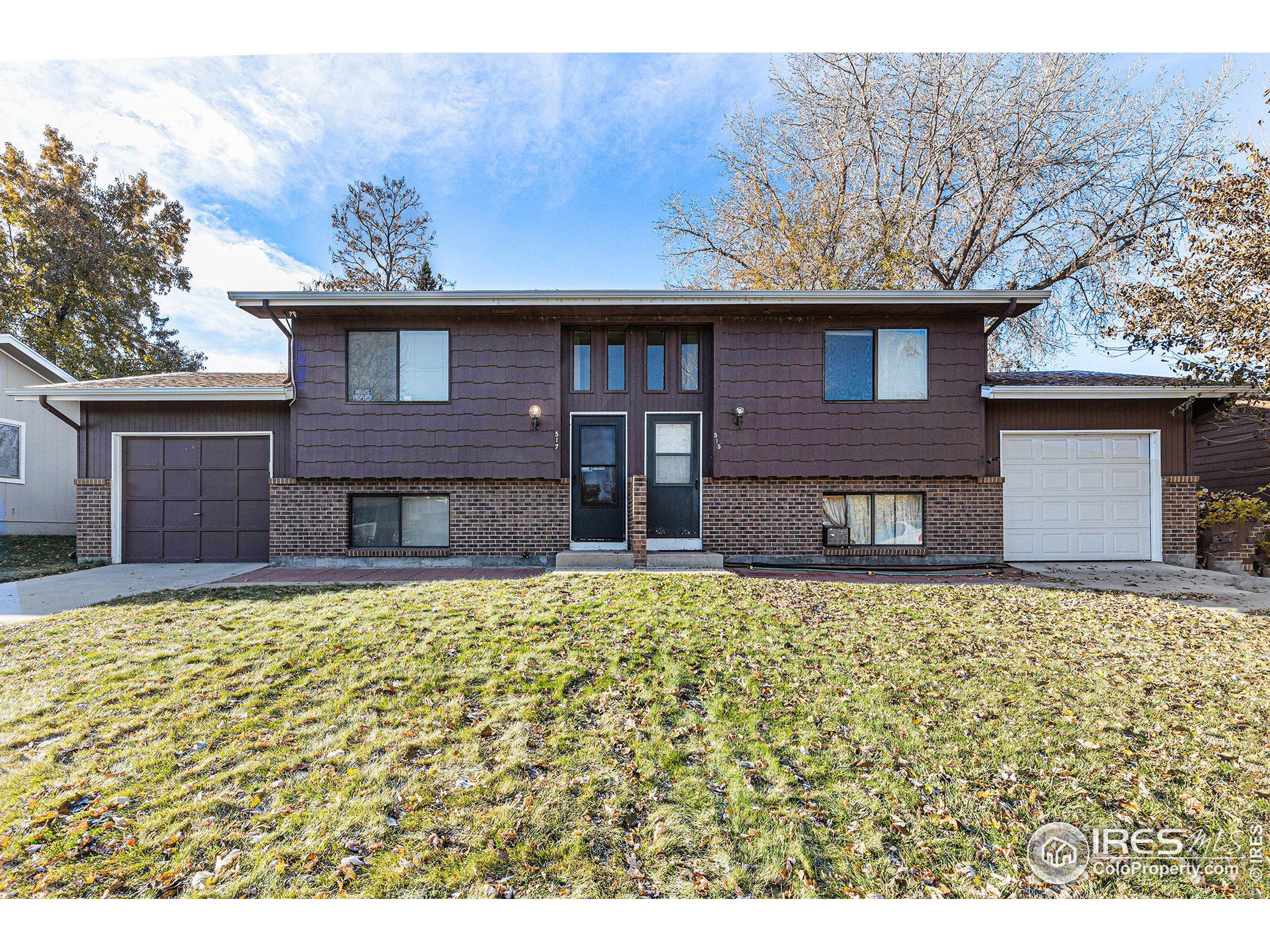 a brick house with a large tree in front of it