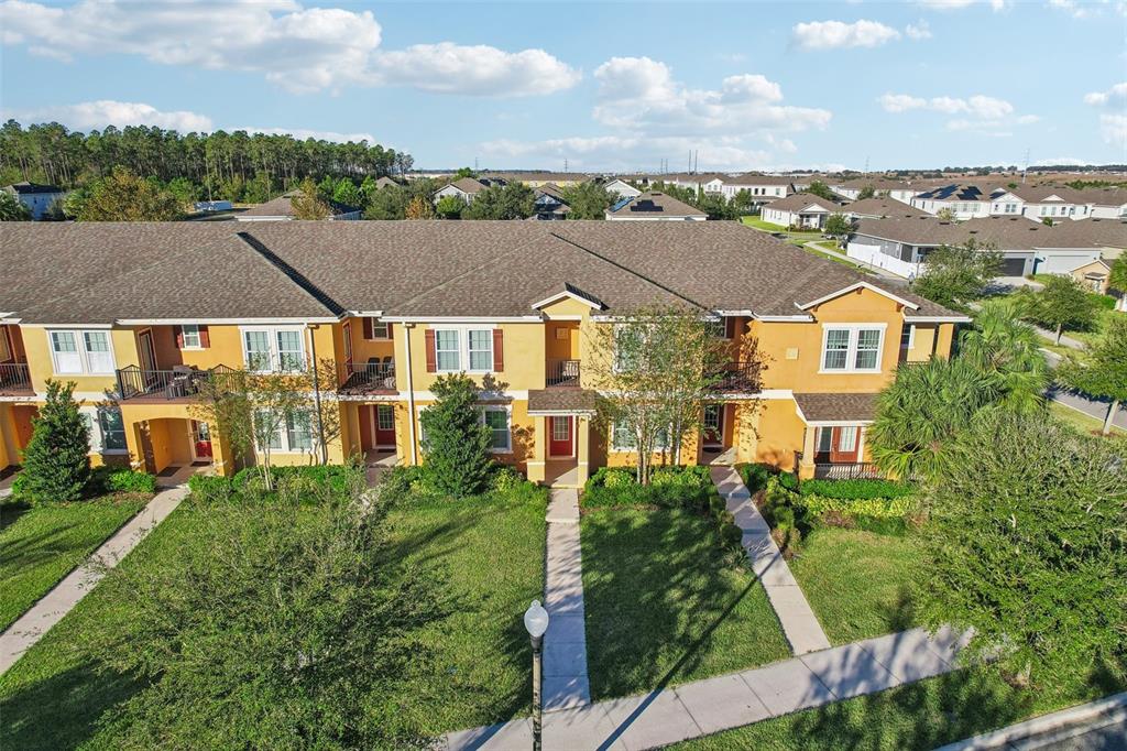 an aerial view of residential houses with outdoor space and trees