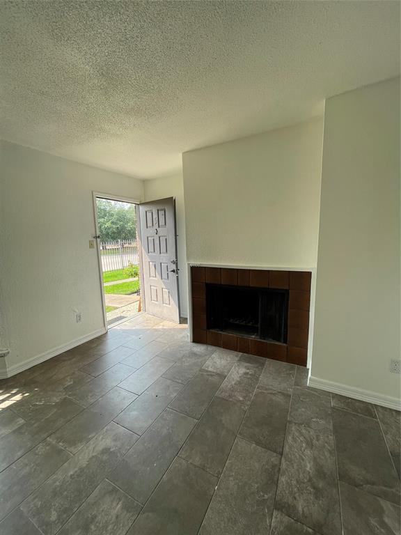 a view of an empty room with a fireplace and a window