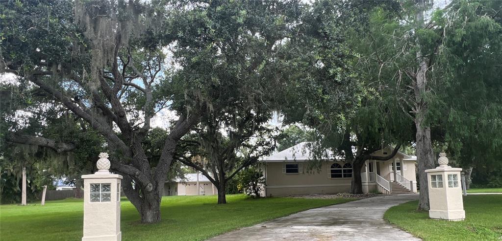 a front view of a house with a garden and tree