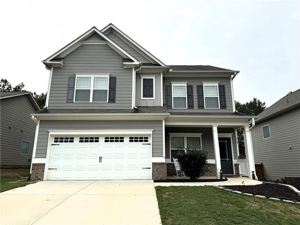 a front view of a house with a garden and yard