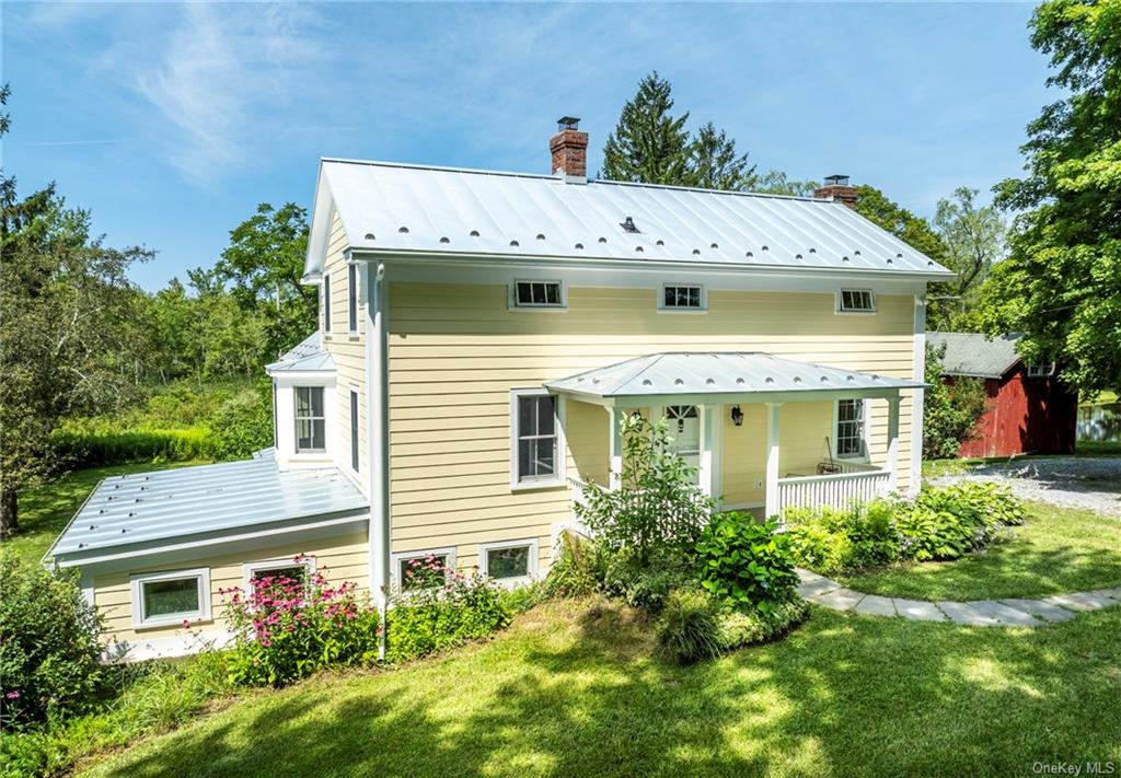 a view of a house with a yard and potted plants