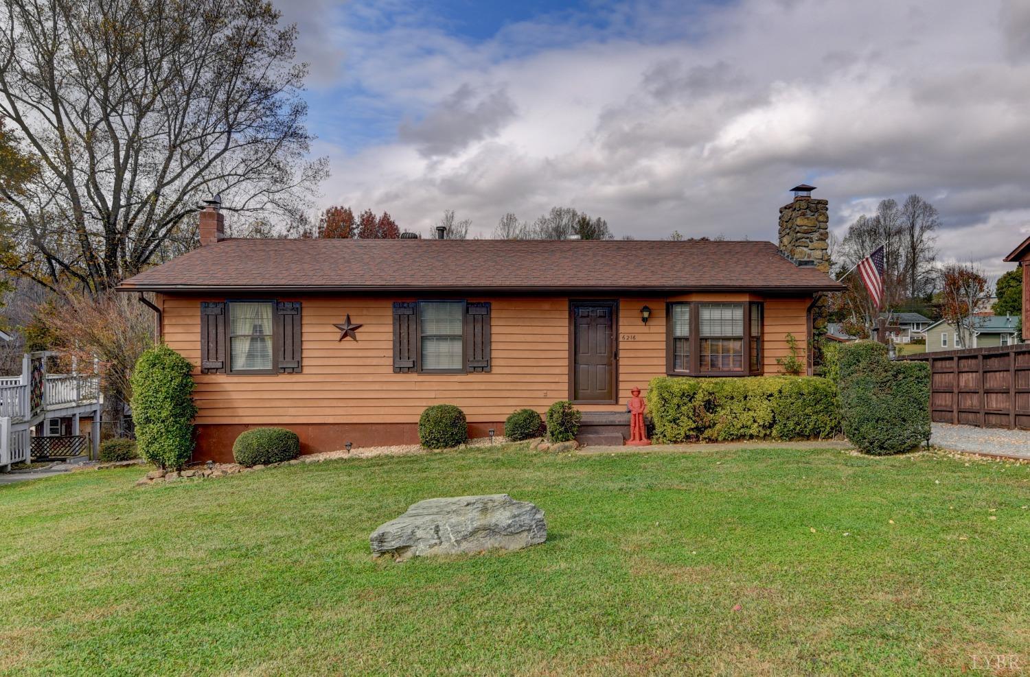 a front view of a house with a yard and trees