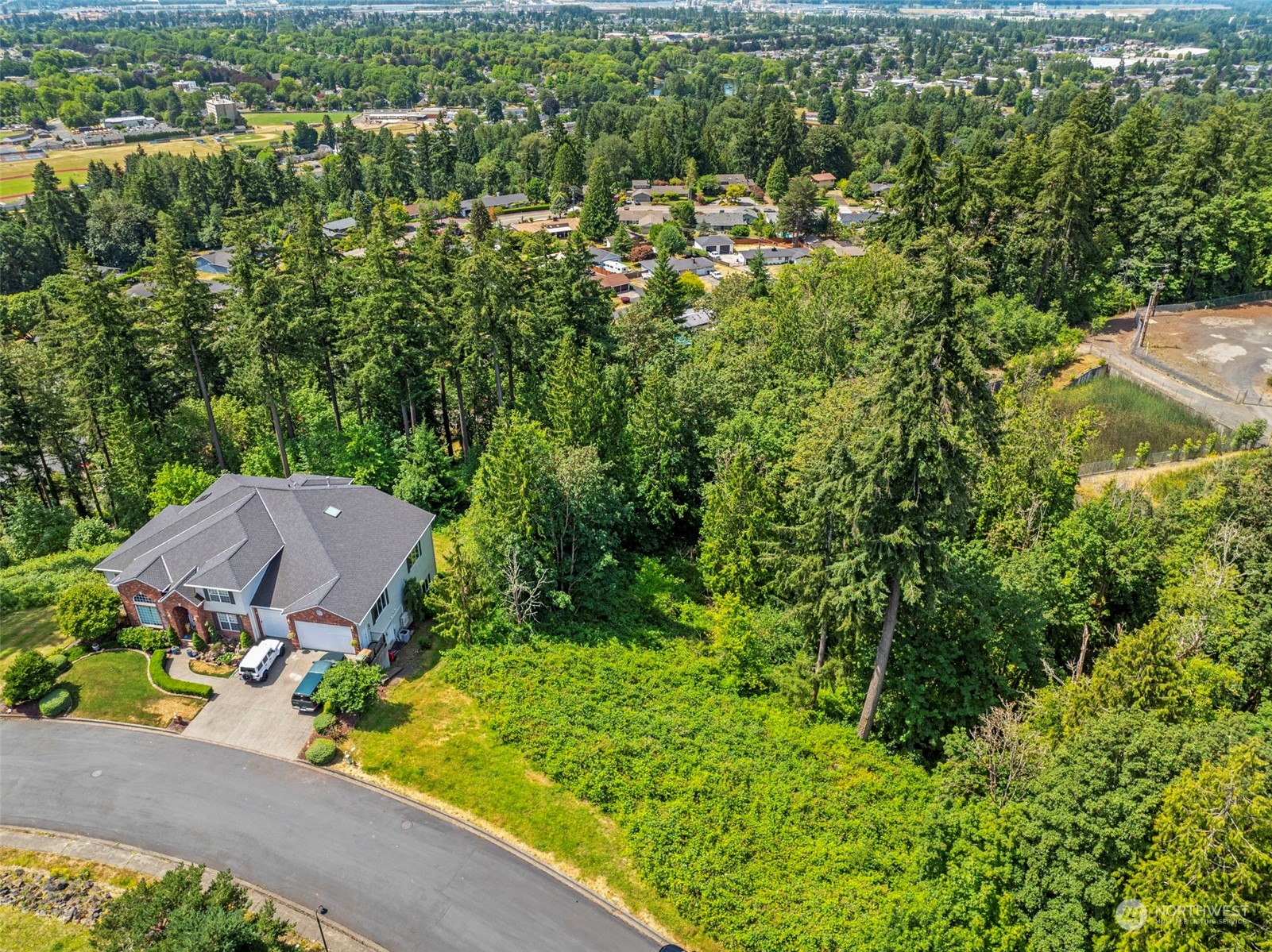 an aerial view of a house with a garden and trees