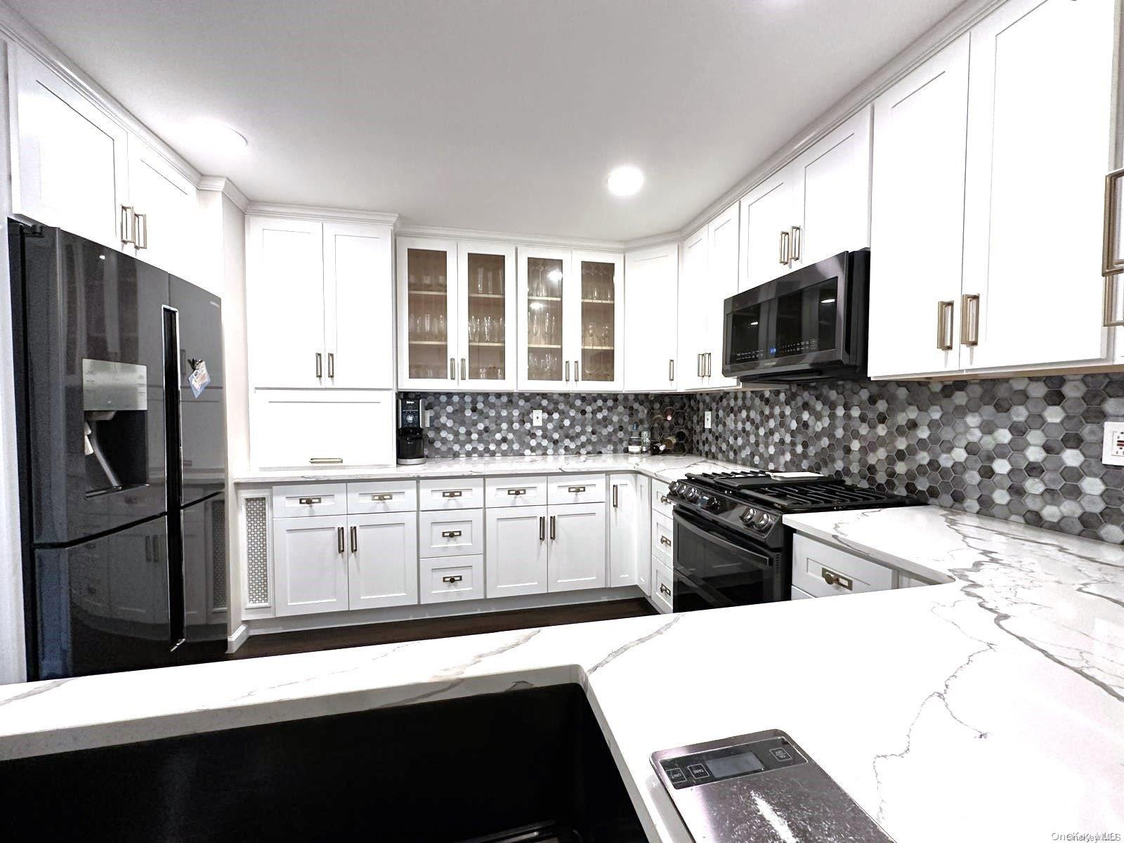 a kitchen with stainless steel appliances a stove sink microwave and refrigerator