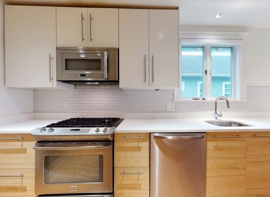 a kitchen with stainless steel appliances granite countertop white cabinets and a stove