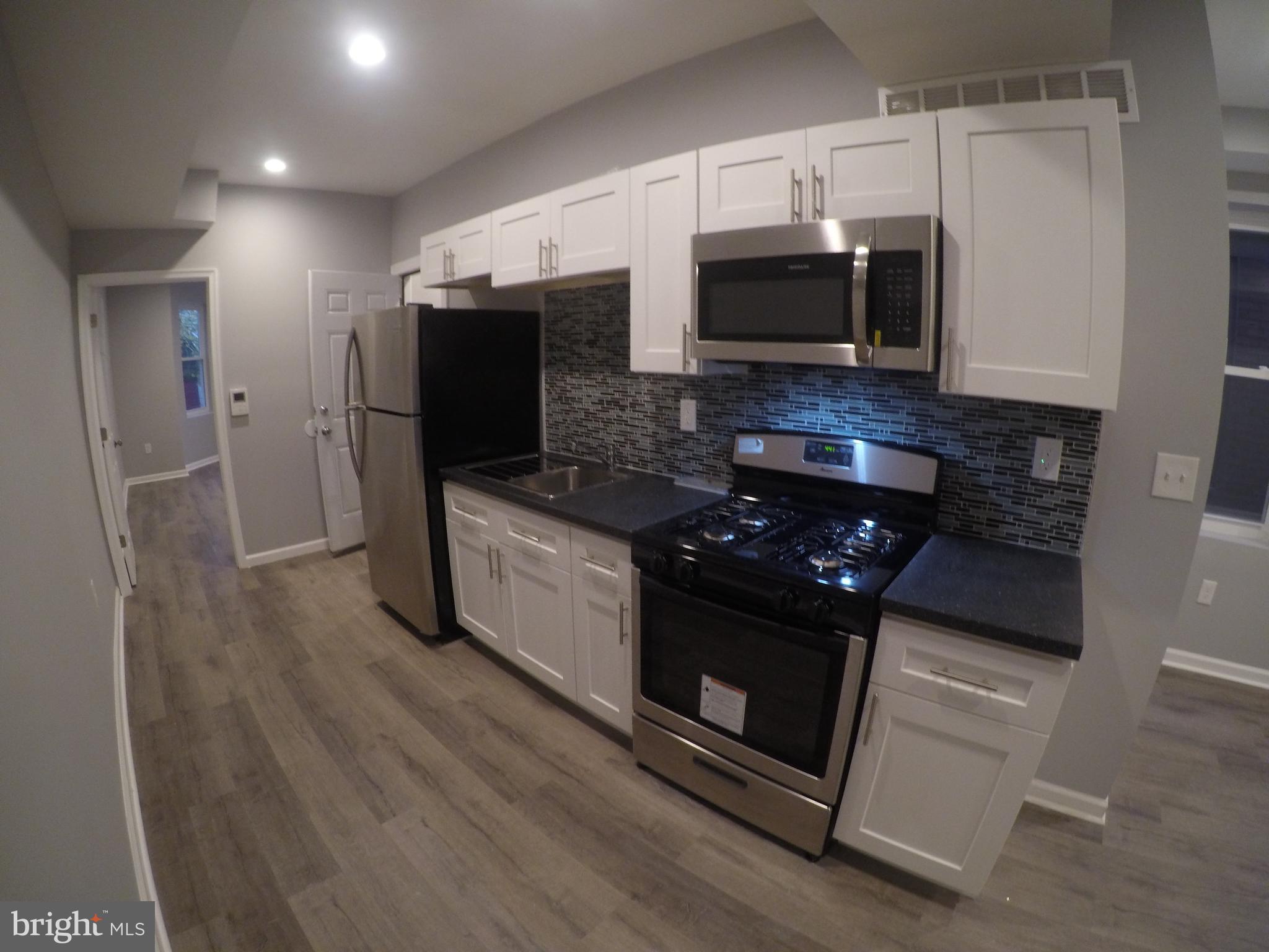 a kitchen with granite countertop a stove and a microwave