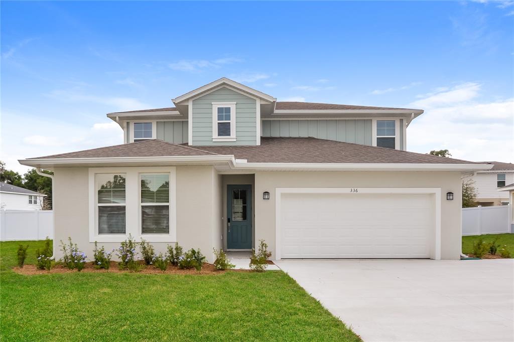 a front view of a house with a yard and garage