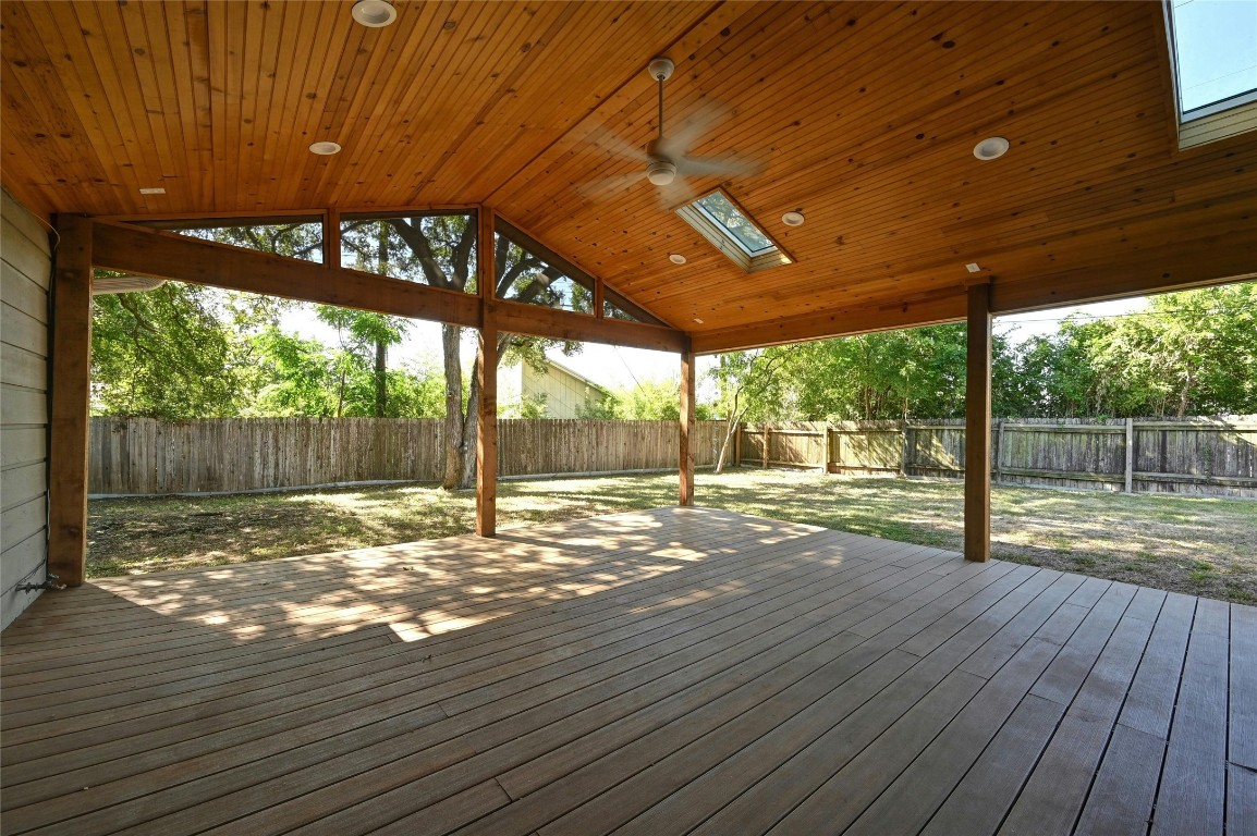 a view of a room with wooden floor and roof with a garden view