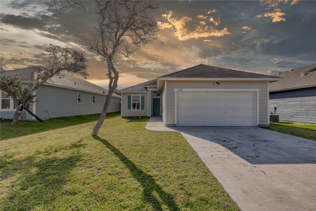 a view of a house with a backyard and a garage