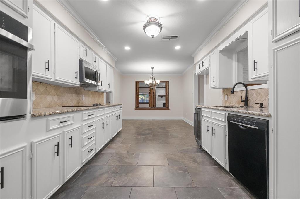 a large kitchen with stainless steel appliances granite countertop a stove and a refrigerator