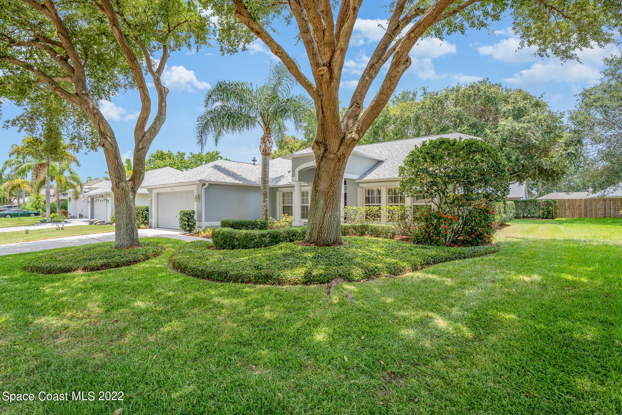 a view of a house with a big yard and large trees