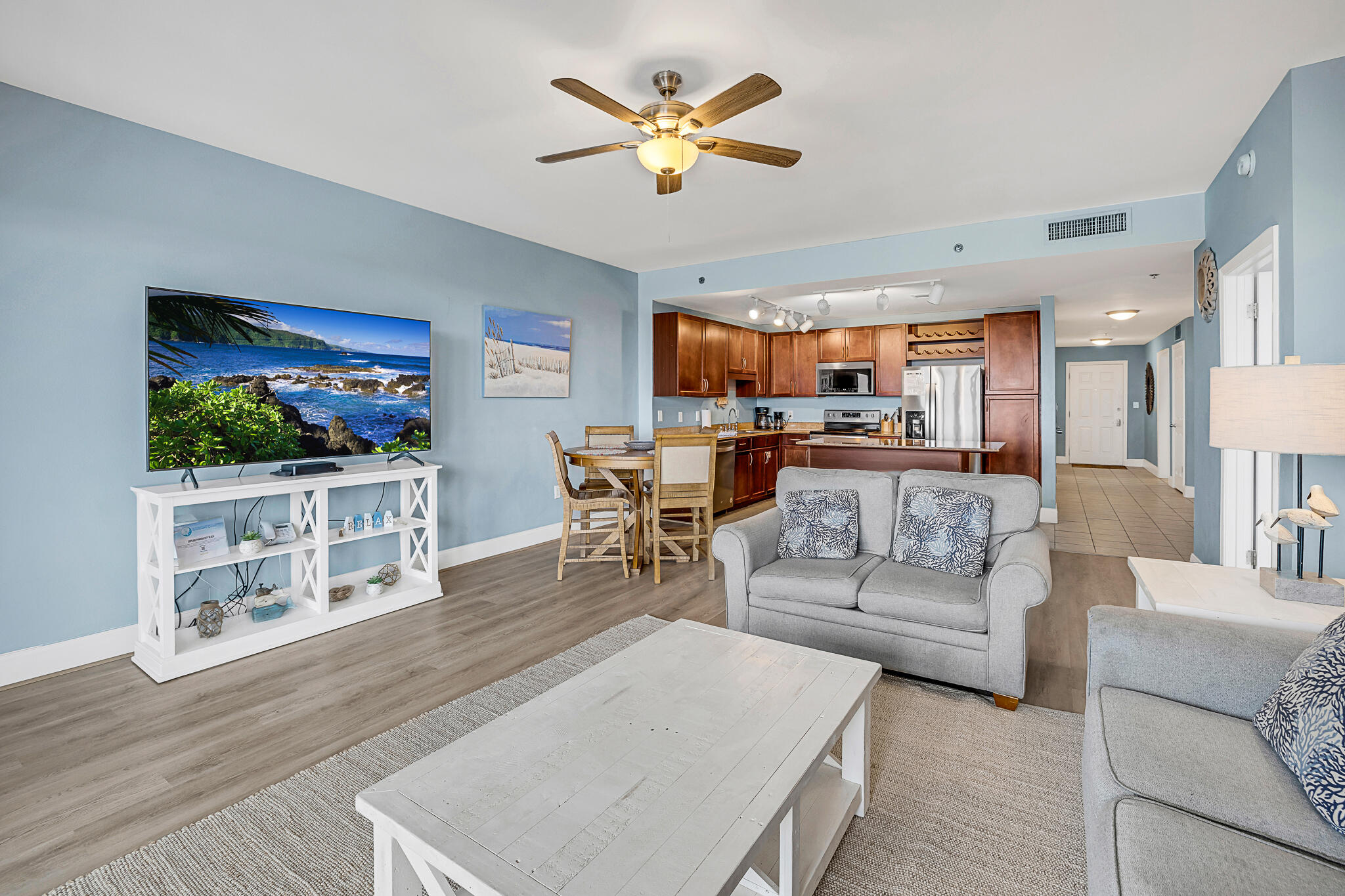 a living room with furniture a flat screen tv and kitchen view