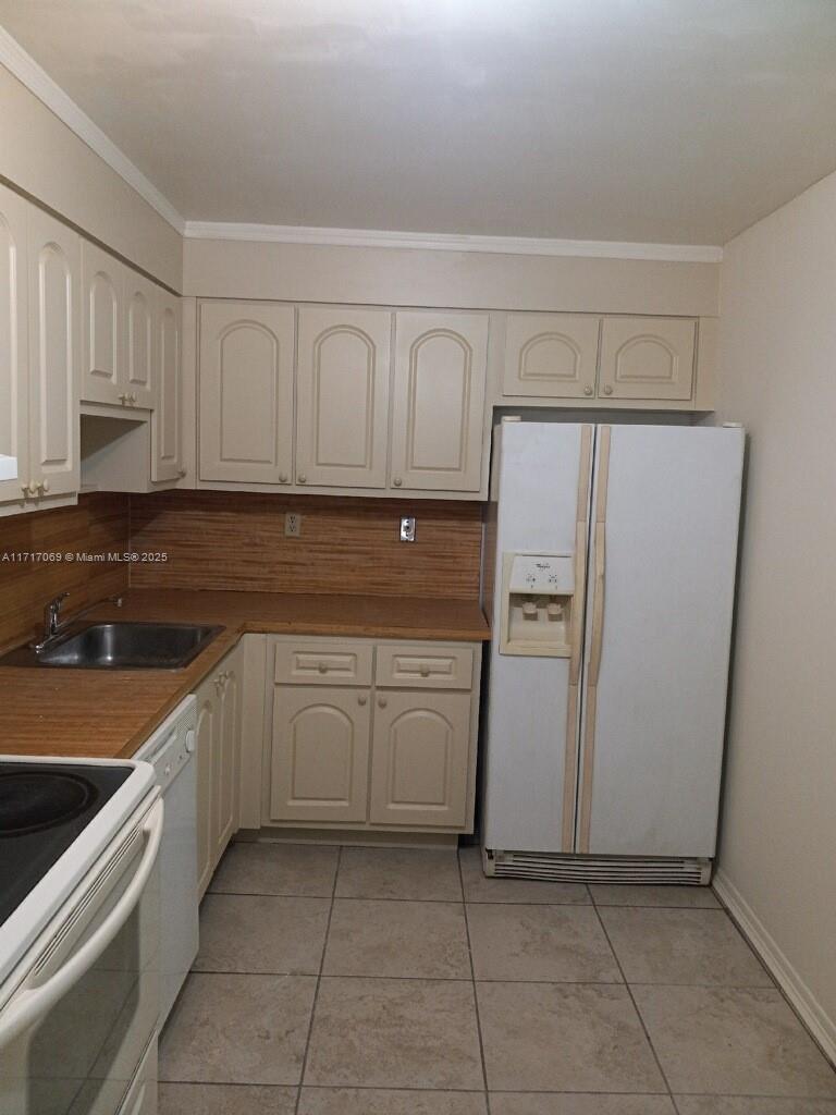 a kitchen with a refrigerator sink and cabinets