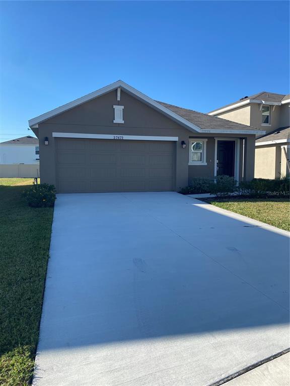 a front view of house with yard and garage