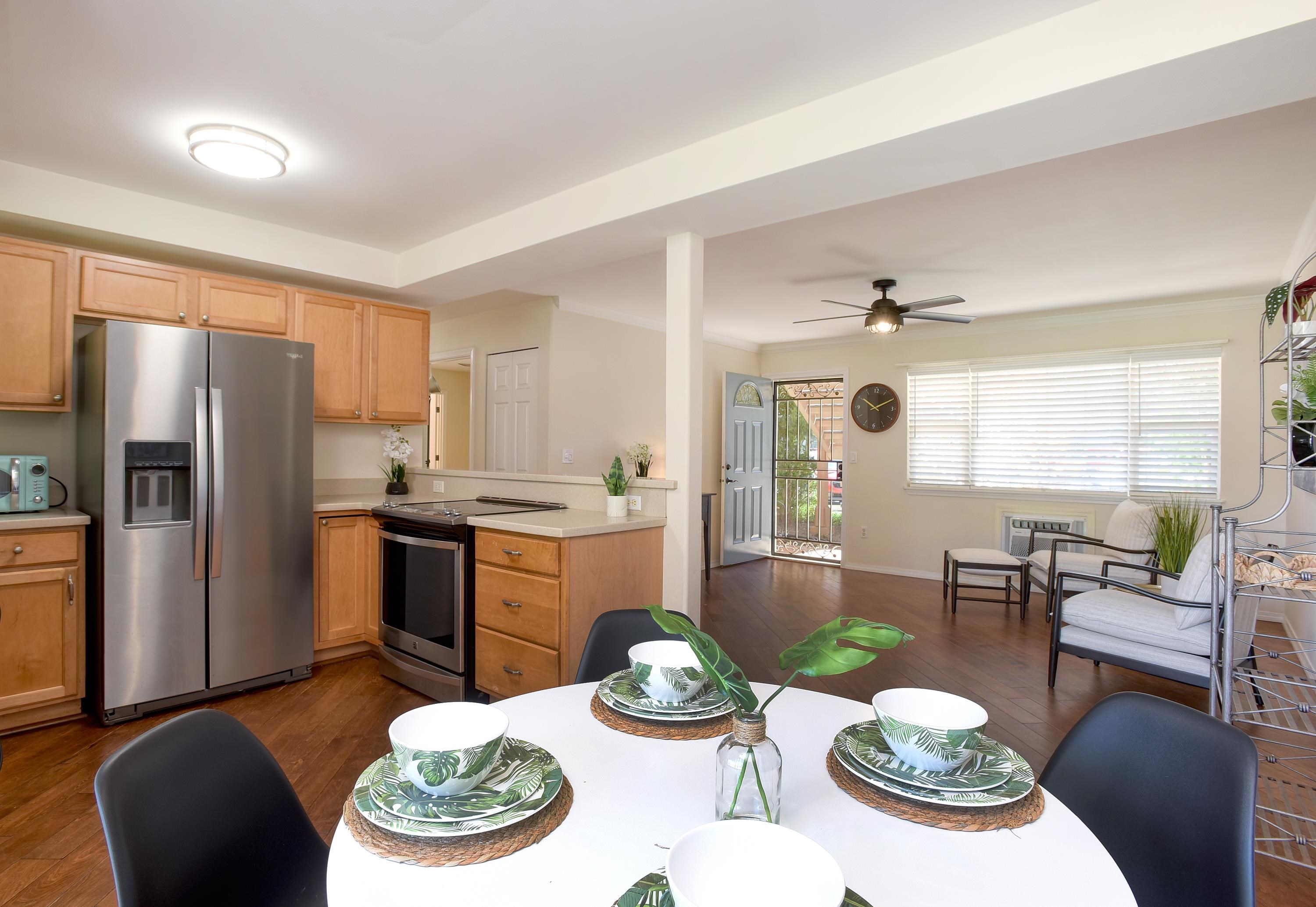 a kitchen with stainless steel appliances granite countertop a dining table and chairs