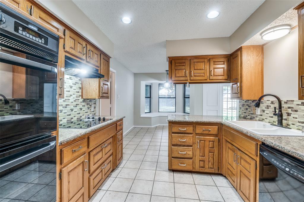 a large kitchen with stainless steel appliances granite countertop a stove and cabinets