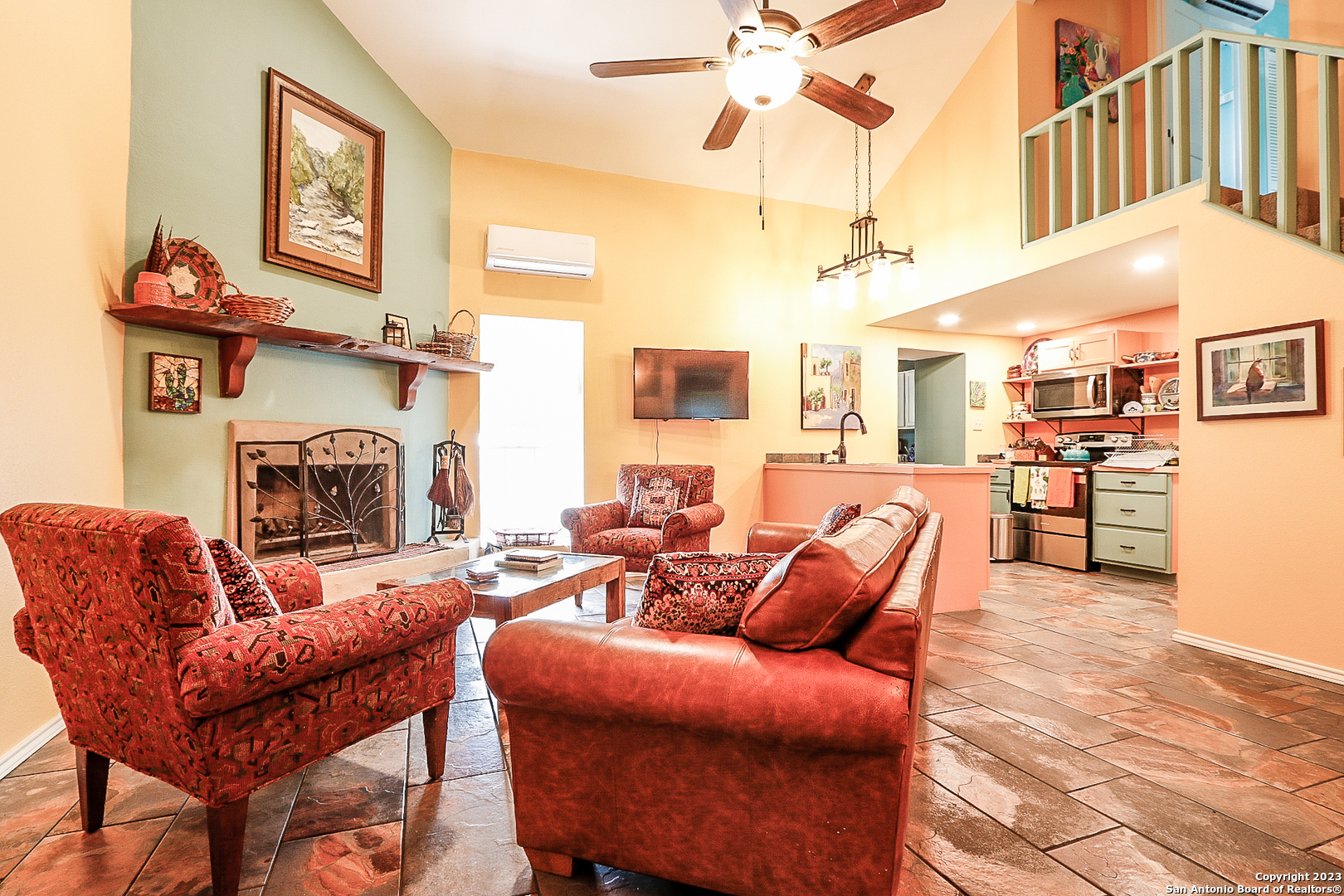 a living room with furniture a fireplace and a chandelier