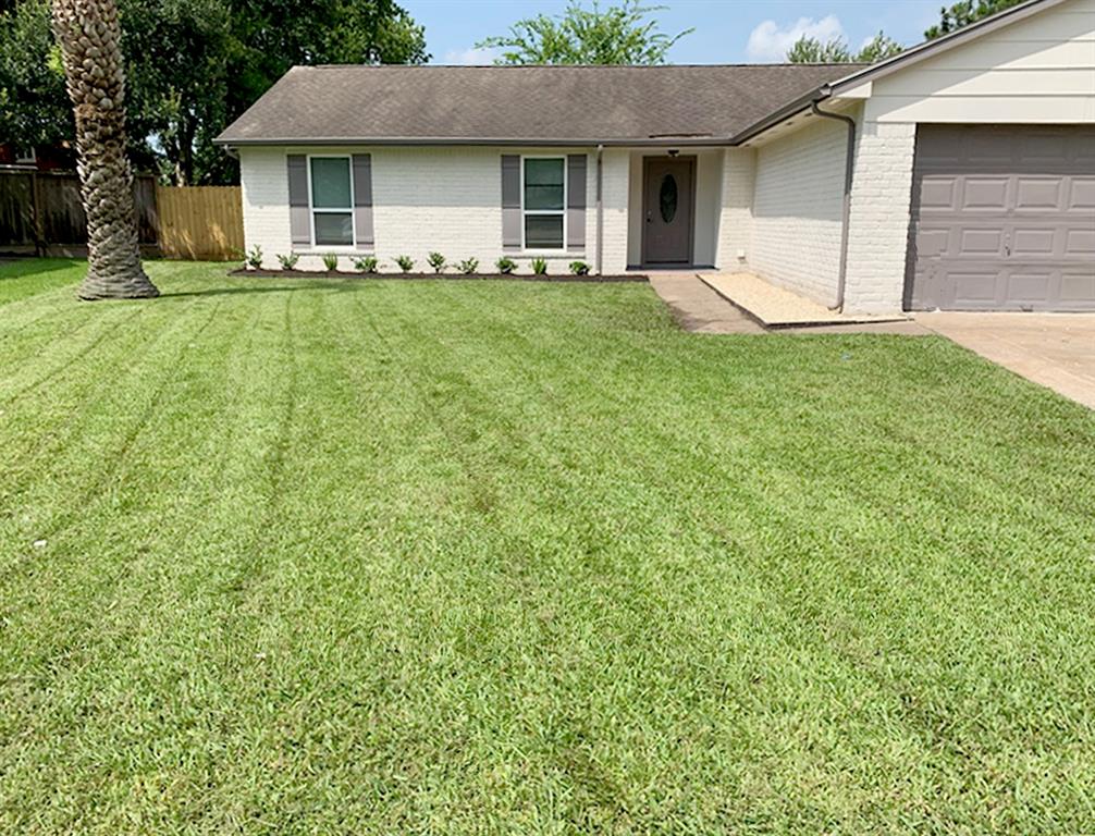 a view of a house with a yard and tree