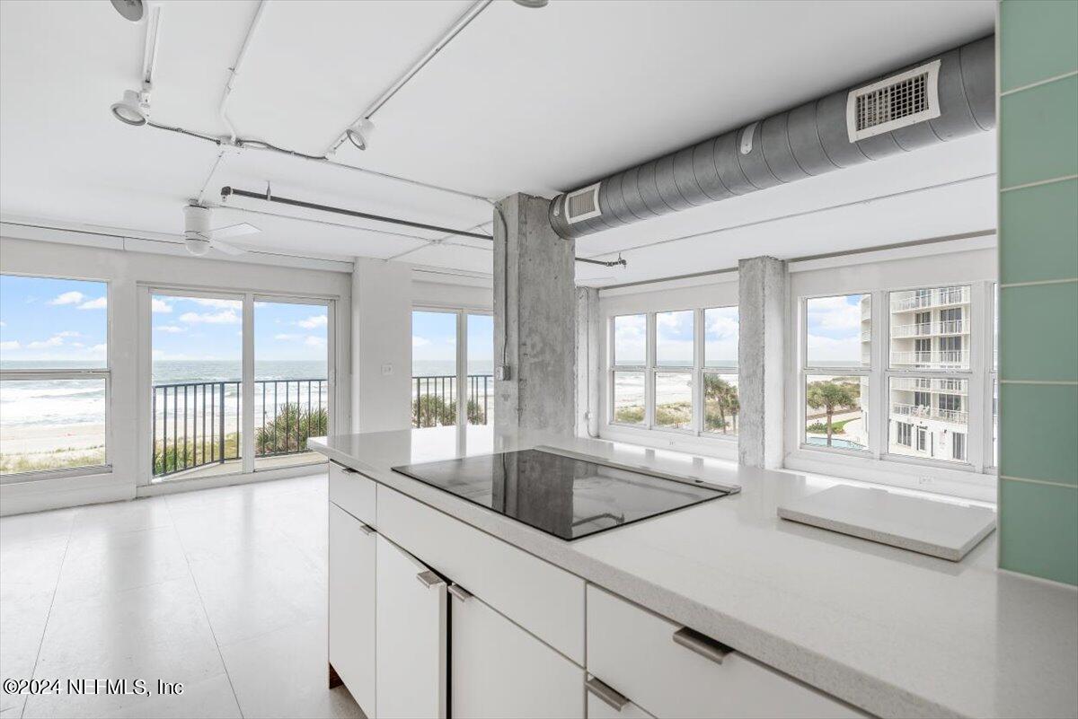 a view of a kitchen with a sink and large windows