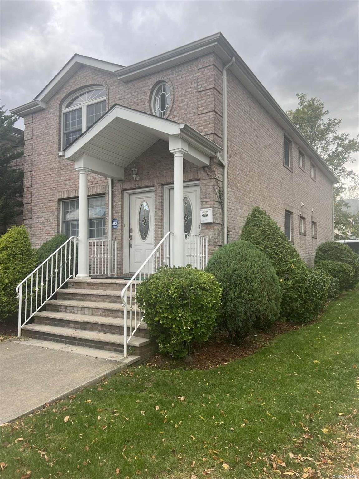 a front view of a house with a garden