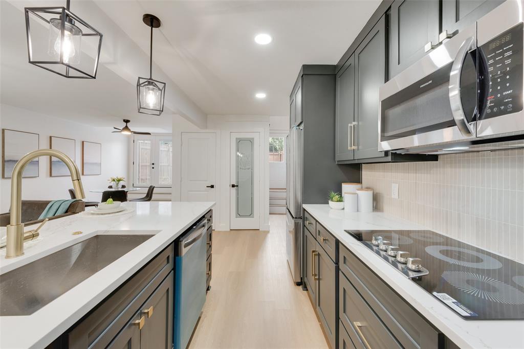 a kitchen with stainless steel appliances granite countertop a sink a stove oven a counter space and cabinets