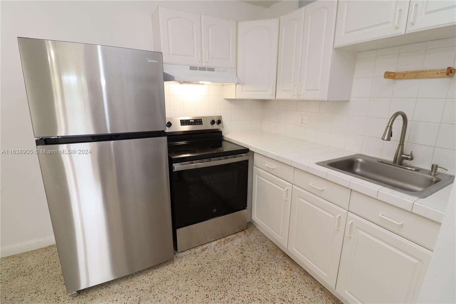 a kitchen with a refrigerator sink and cabinets