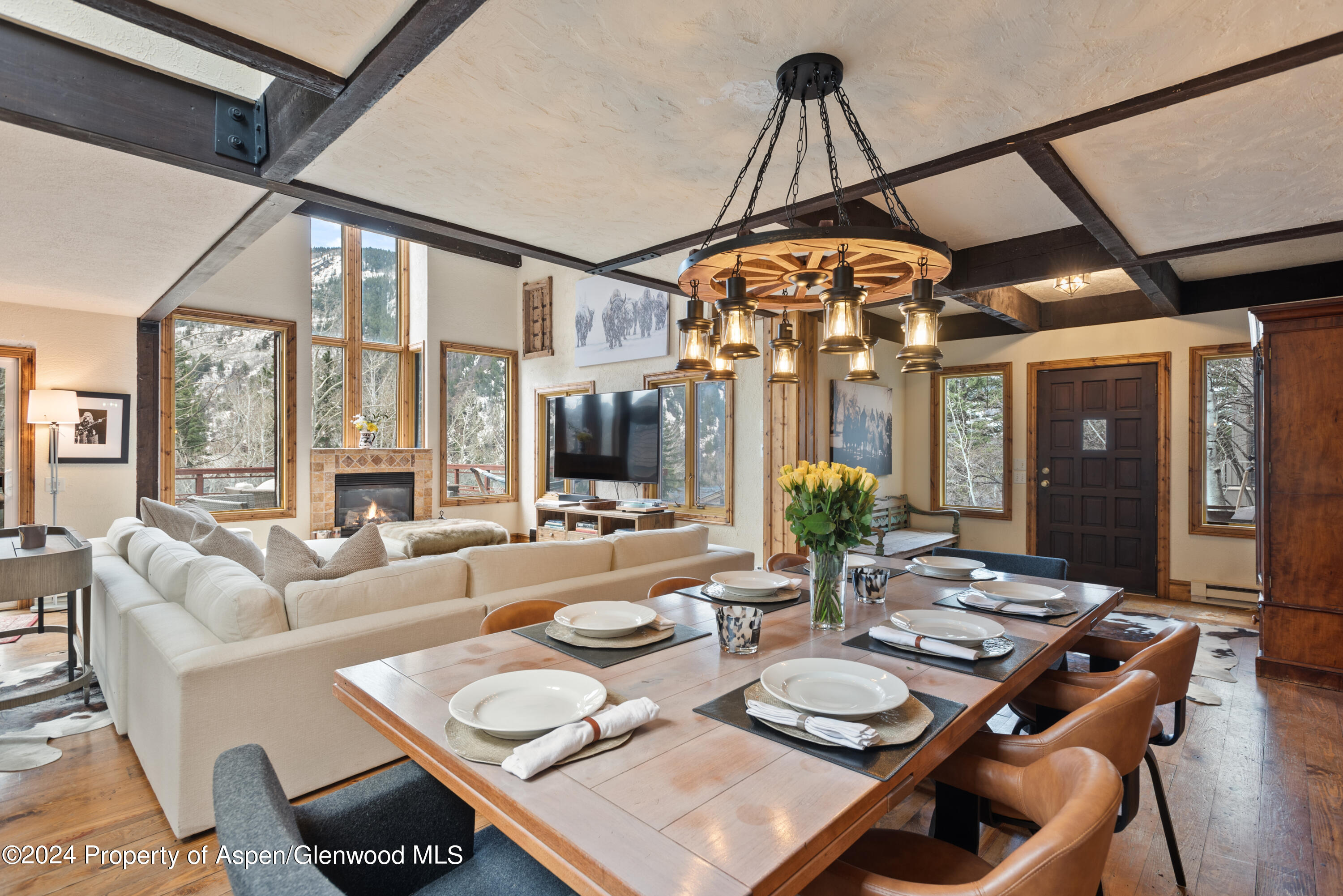 a dining room with furniture a chandelier and wooden floor