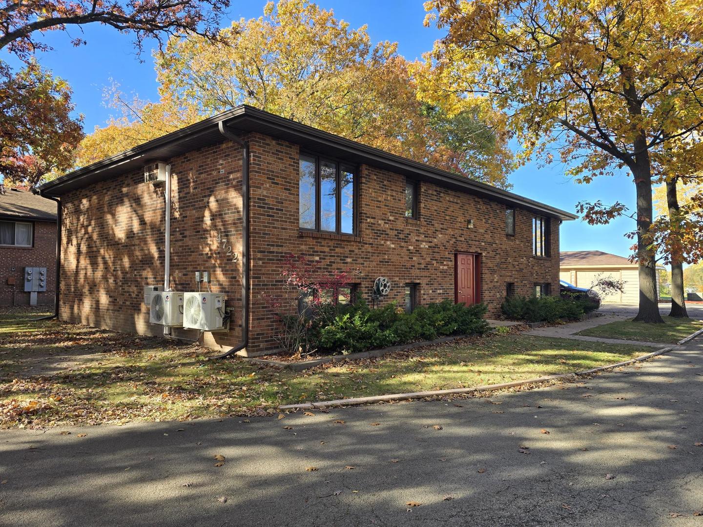 a view of brick house with a yard