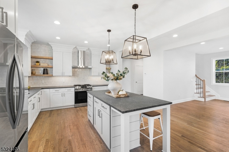 a kitchen that has a lot of cabinets in it and wooden floor