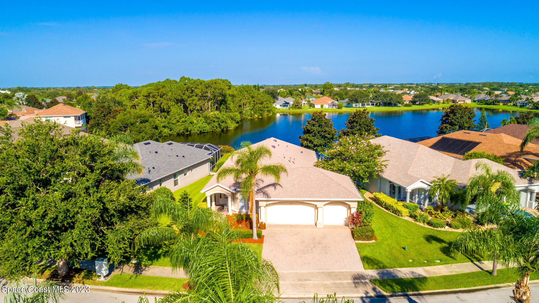 an aerial view of a house with a swimming pool a yard and mountain view in back