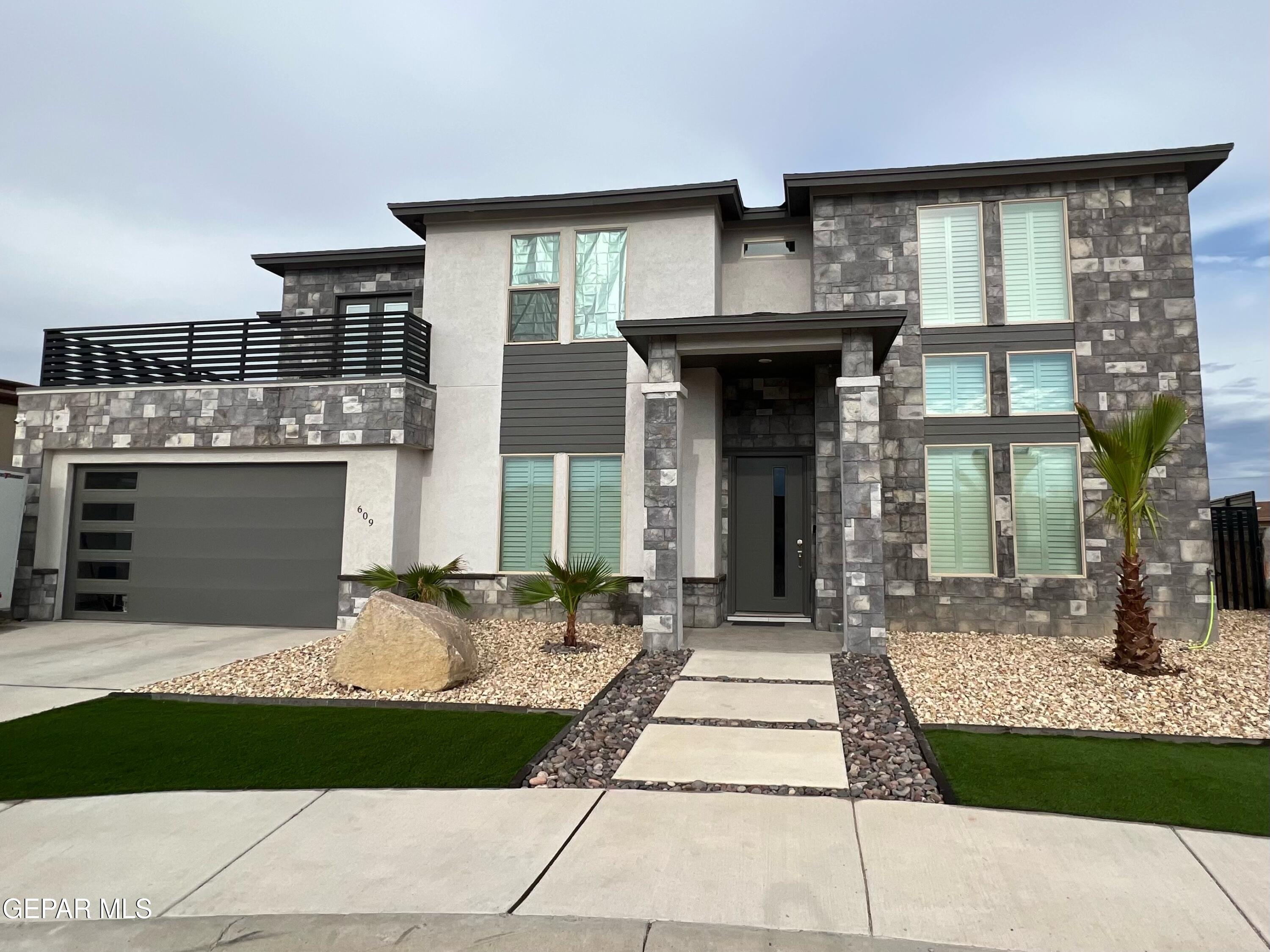 a front view of a house with a yard and garage