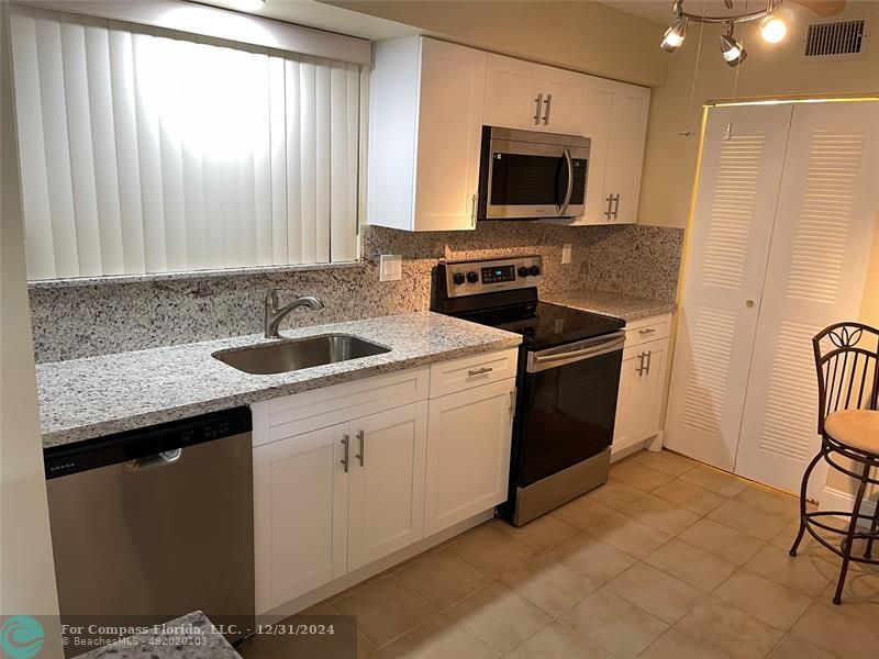 a kitchen with a stove a sink and a microwave